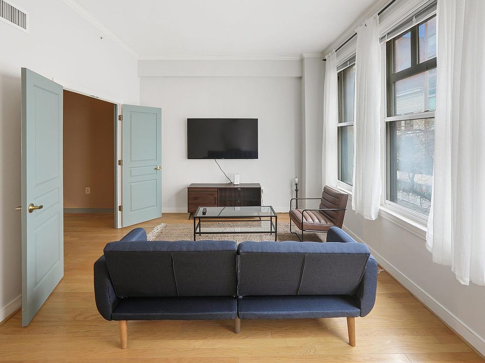 Living Room flooded with natural light, and 60" Smart TV with full cable package waiting for you