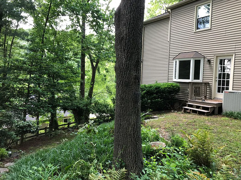 Back of house viewed from path to the woods. On the left is the lower area and the patio outside of the Guest Suite.