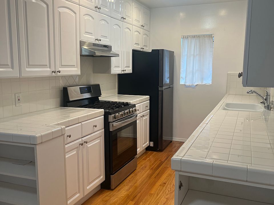 Renovated Kitchen with new white tile and tons of recessed lighting