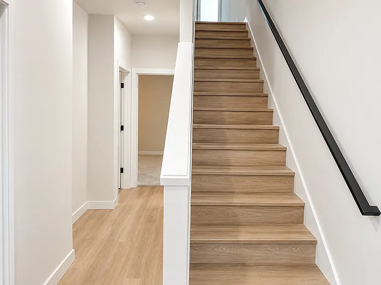 Hallway showcasing the two bedrooms downstairs and the stairs leading to the the living area