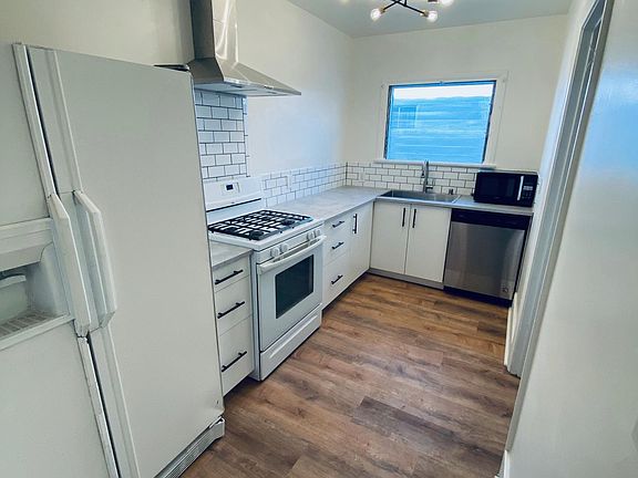 Newly updated kitchen with fridge, gas stove, microwave, new vent and dishwasher.