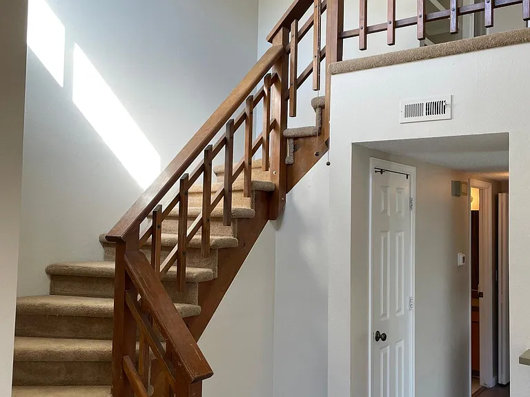 Stairs to utility closet and master bedroom and bath with walk-in closet