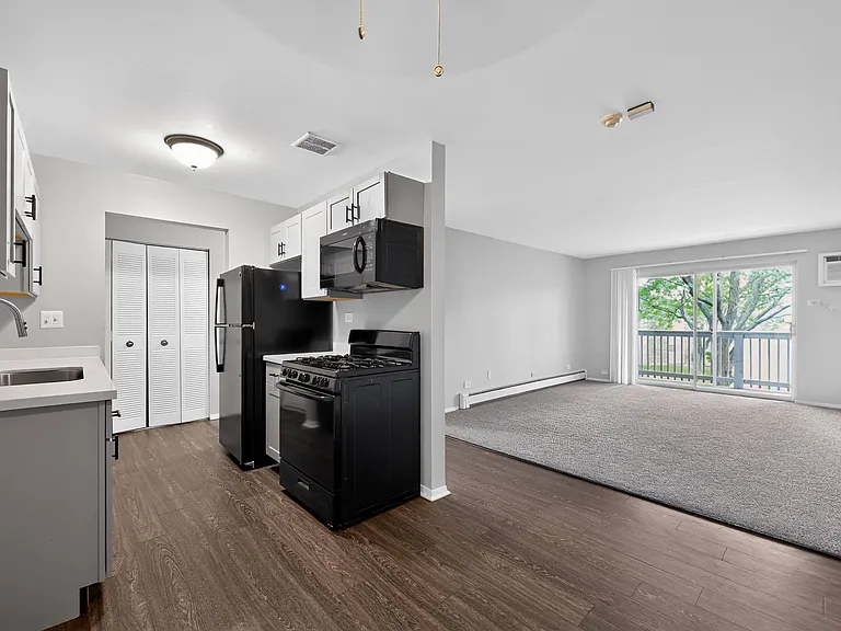 Enjoy a clean, modern kitchen featuring sleek black appliances at Renaissance at Carol Stream in Carol Stream, IL.