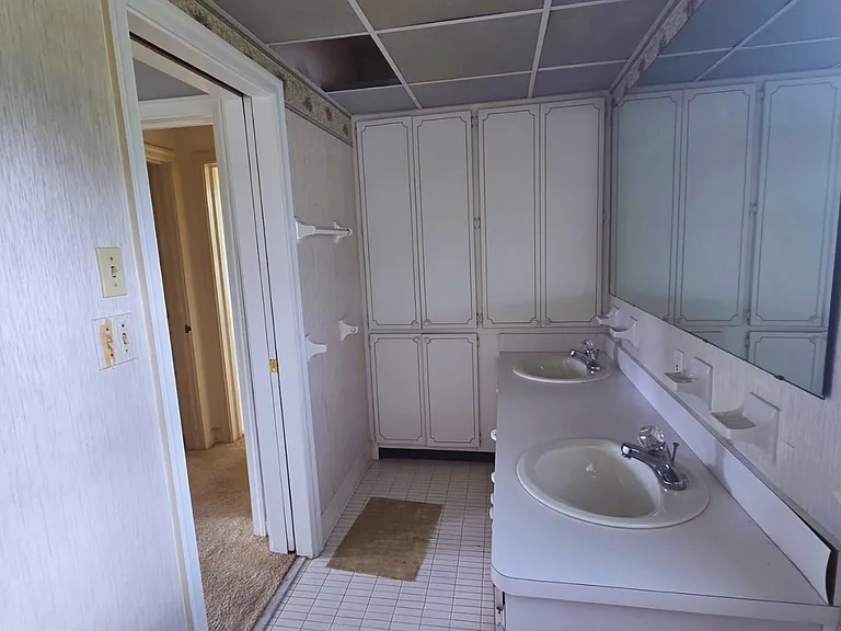 Bathroom with expansive mirror and two functional washbasins