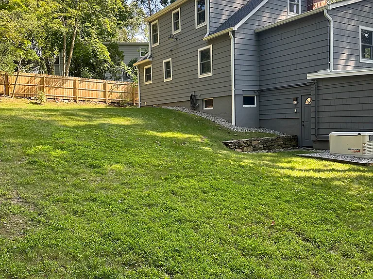 The backyard. Private, fenced in, surrounded by beautiful trees.