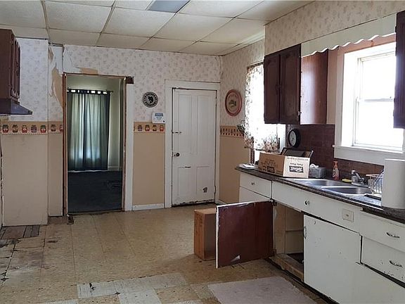 Kitchen from front door. Doorway to LR on left and basement on the right
