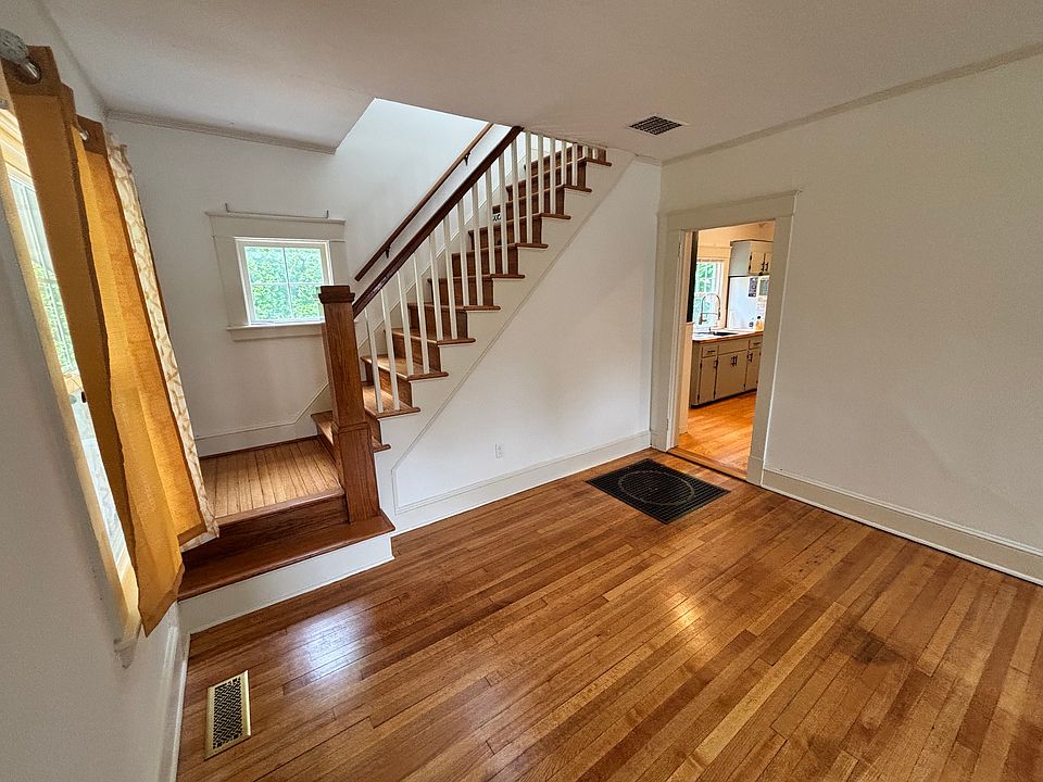 Main living area and entrance showing stairs, refurbished hardwood floor(done throughout) and kitchen entry.