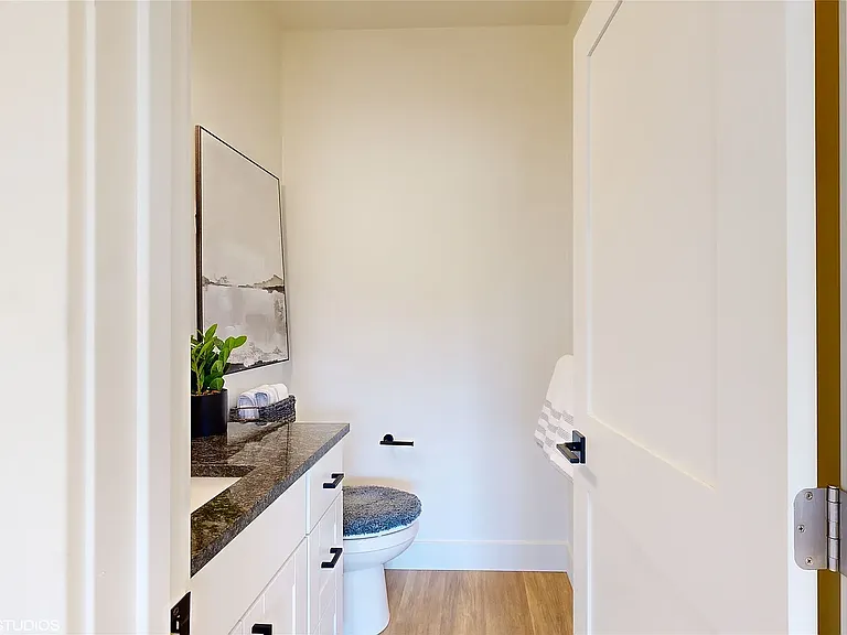 Elegant main-level powder room featuring modern finishes, sleek black accents, and a clean contemporary design conveniently located off the private TV and lounge sitting area.