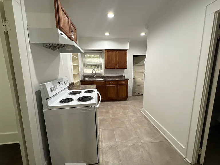 Kitchen - unit comes with a fridge. Past the kitchen is a dedicated laundry room.