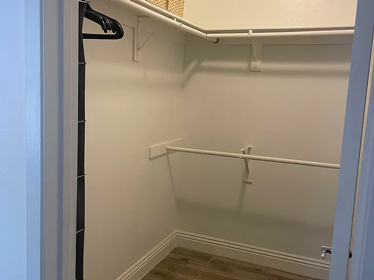 Primary walk-in closet.
Includes items shown: 3 storage baskets, hangers, and rack for accessories.