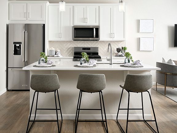 Example of Kitchen- White countertops and cabinetry and herringbone backsplash