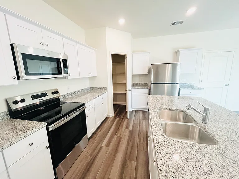 Kitchen - Left View with Pantry, Refrigerator and Garage access