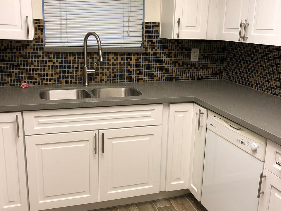 Kitchen glass mosaic backsplash and stainless steel double sink with upgraded high arc single handle brush nickel faucet.