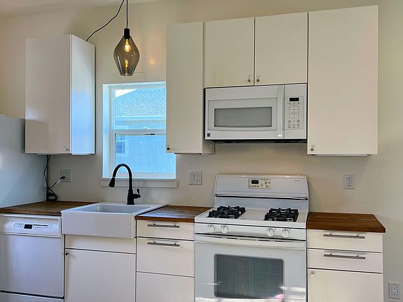 Kitchen featuring new fridge, ample storage and stylish light fixture