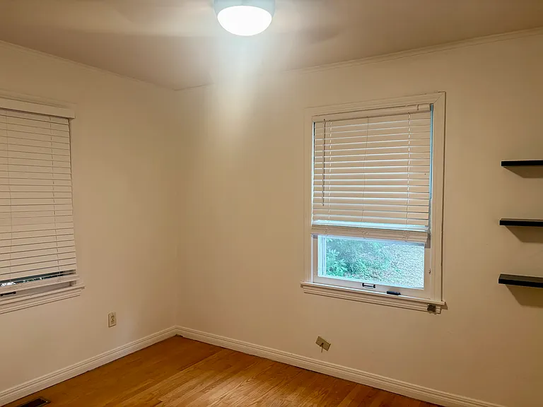 Second bedroom with window facing backyard, ceiling fan.