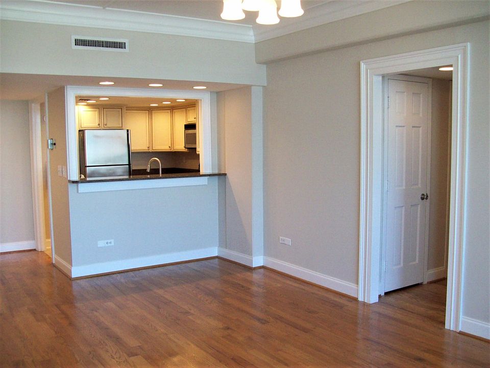 living area with kitchen. entrance door is to the left of the kitchen.