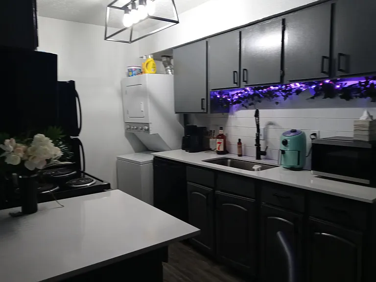 Streamlined kitchen with ample cabinet storage, subway-tile backsplash, and a full appliance set plus in-home laundry.