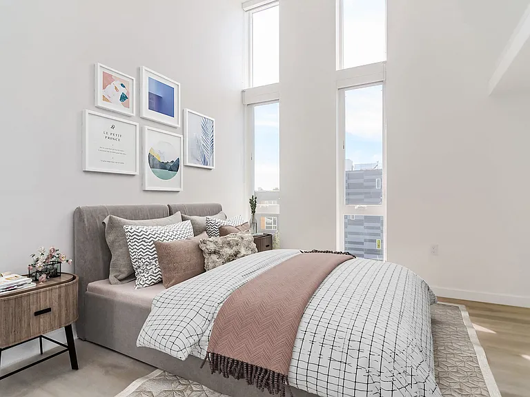 Bright bedroom with a bed and large windows at Alt Capitol Hill.