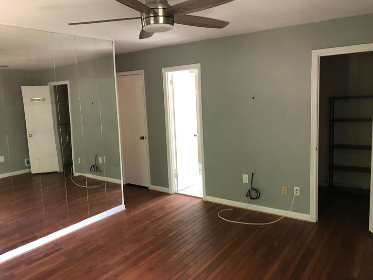 Master bedroom from front of room. First door on left is the small closet, second is door to bath, and third is entrance to walkin closet