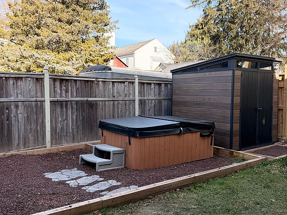Private fenced in backyard with shed, grill and hot tub.