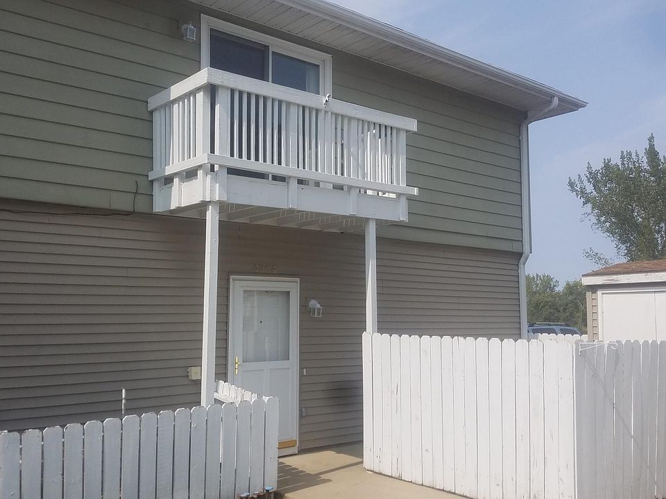Main entry door and balcony, privacy fence around patio and shed
