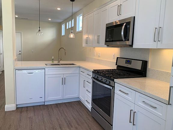 Brand new bright kitchen with 5 burner gas stove and quartz countertops