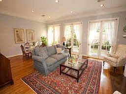 Another view of living/dining room which features wall of french doors opening onto lushly landscape