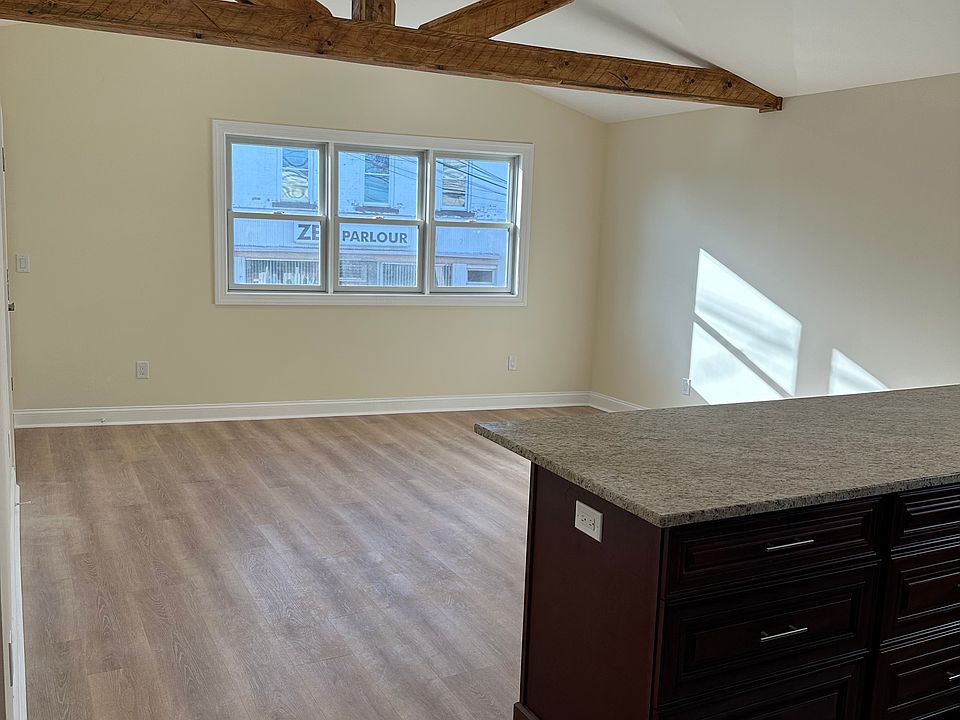 Living Room with tray ceiling and exposed beams- also has large closet for storage