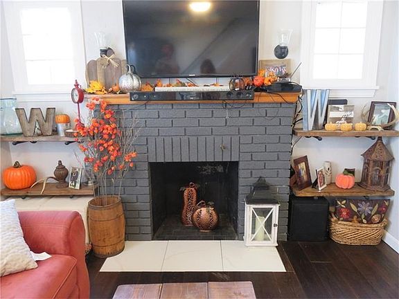 The fireplace with painted bricks and ceramic hearth flanked by pocket windows adds charm to the LR.