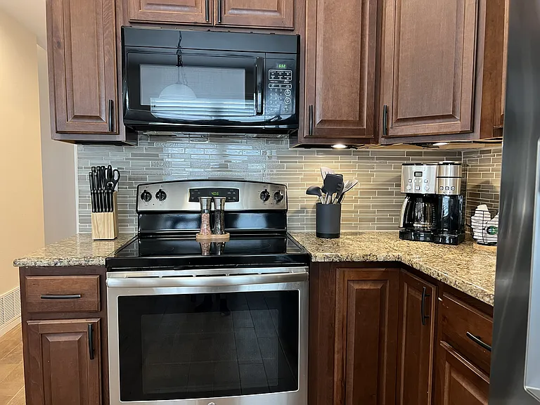 Gourmet kitchen featuring granite counters, tile backsplash, and stainless steel appliances.