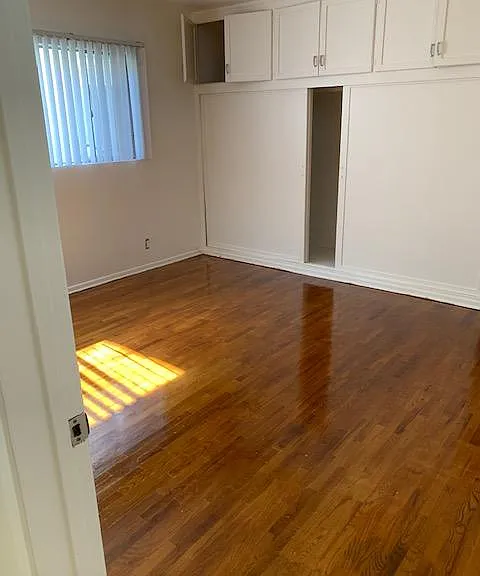 Bedroom with large closet & storage cabinets.