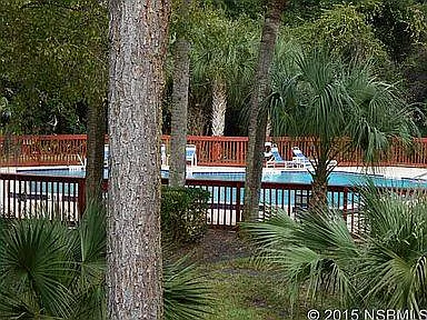 The private, community pool is just steps beyond the treed backyard.