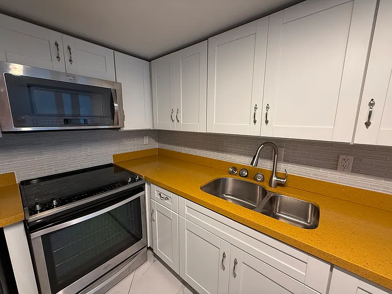 Open concept KITCHEN with limited edition custom quartz countertops, dimmable designer lighting & like-new LG & Whirlpool appliances