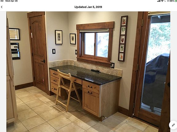 Desk area in kitchen, door to deck with gas grill.