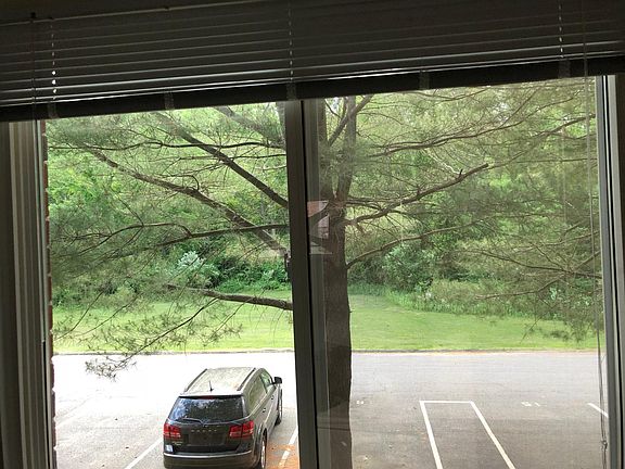 Back side of apartment opening up to a big field surrounded 