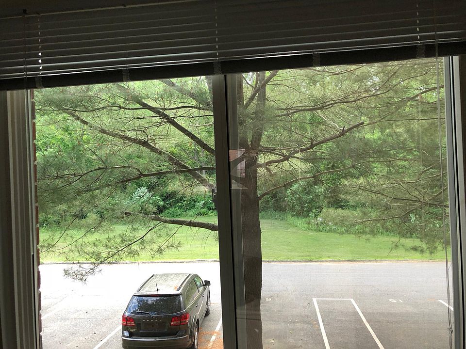 Back side of apartment opening up to a big field surrounded 