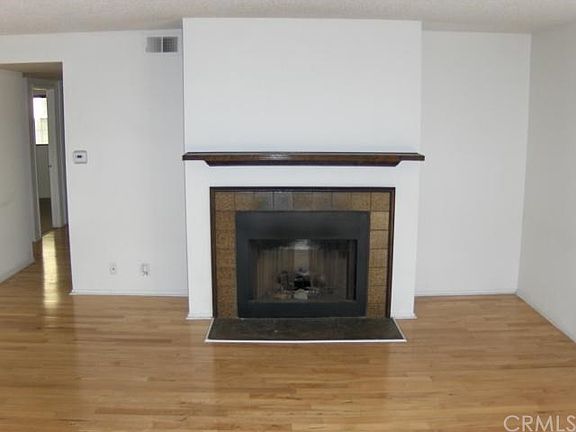 Living room with fireplace and maple hardwood floors.