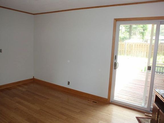 Family Room located to the back of the home with wood flooring & Sliding door to the wood deck.