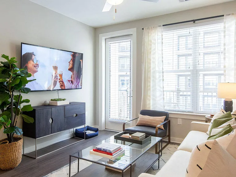 Living Room with Wall-Mounted TV, Coffee Table, and Balcony Access
