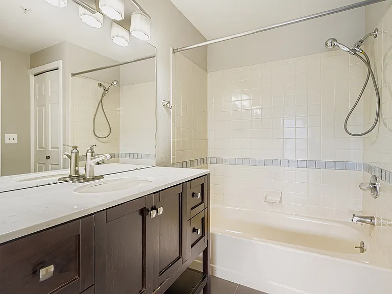 Bathroom with updated lighting, vanity, and grey tile flooring