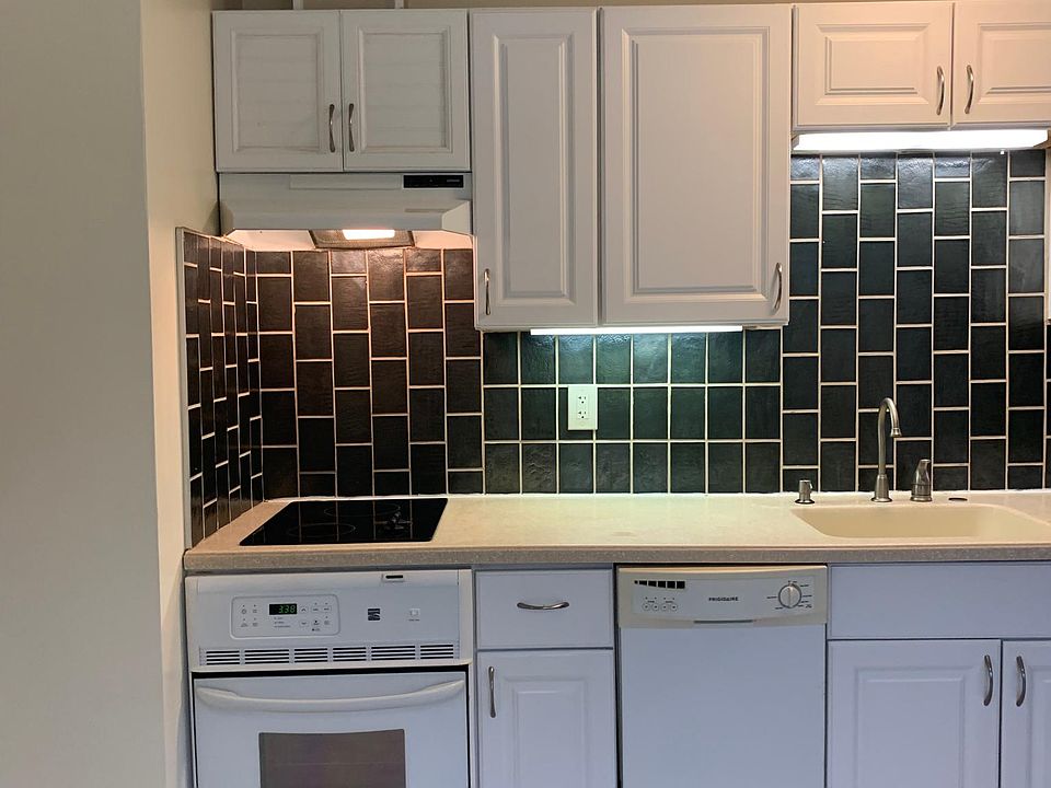 Kitchen with glass tile backsplash, 2 burner smooth cooktop, oven and dishwasher.