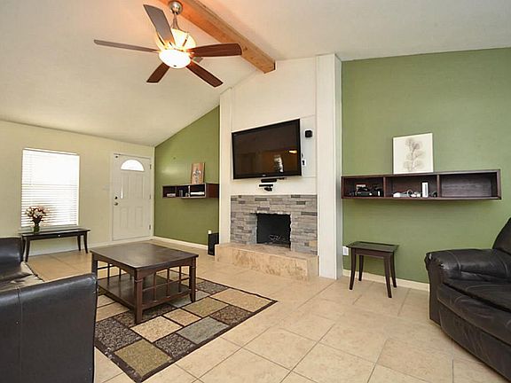 FAMILY ROOM WITH LARGE TV AND FIREPLACE.