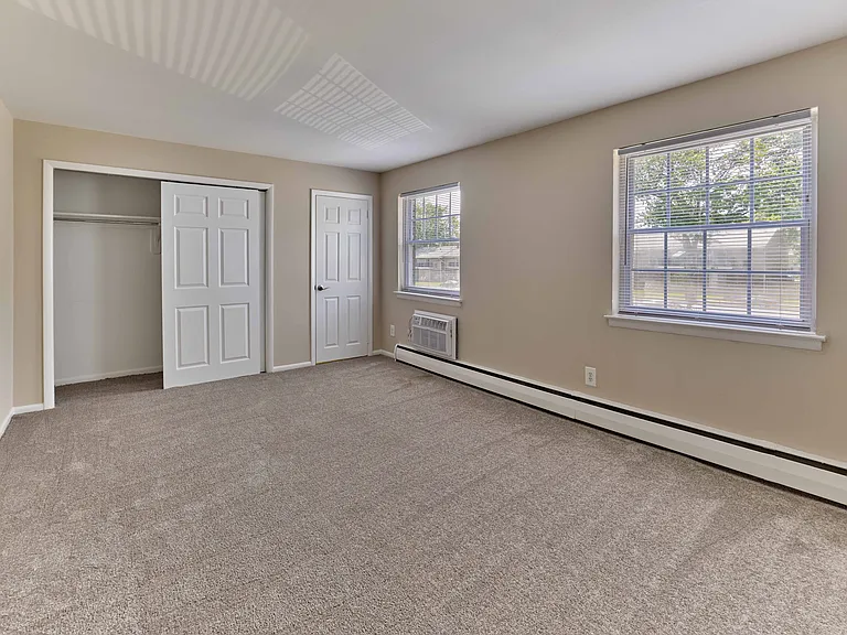 Bright and roomy bedroom with plush carpet and ample closet space at Maple Terrace Apartments in Maple Shade, NJ