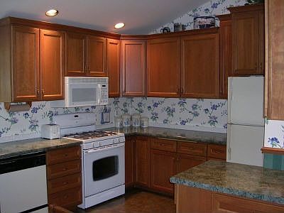 Ample cherry cupboards in roomy, well laid-out kitchen