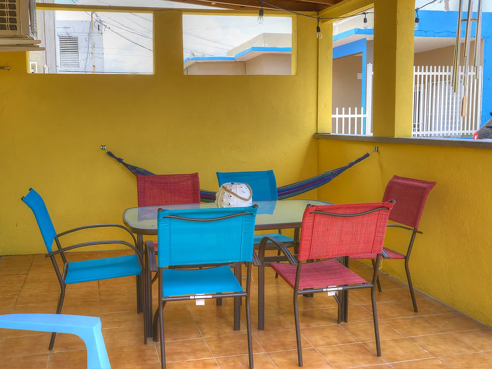 Private outdoor covered patio, with dining space and hammock.