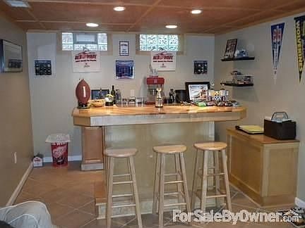 bar in basement : has sink and mini fridge. tile floor by bar. shower in basement is tiled walk-in