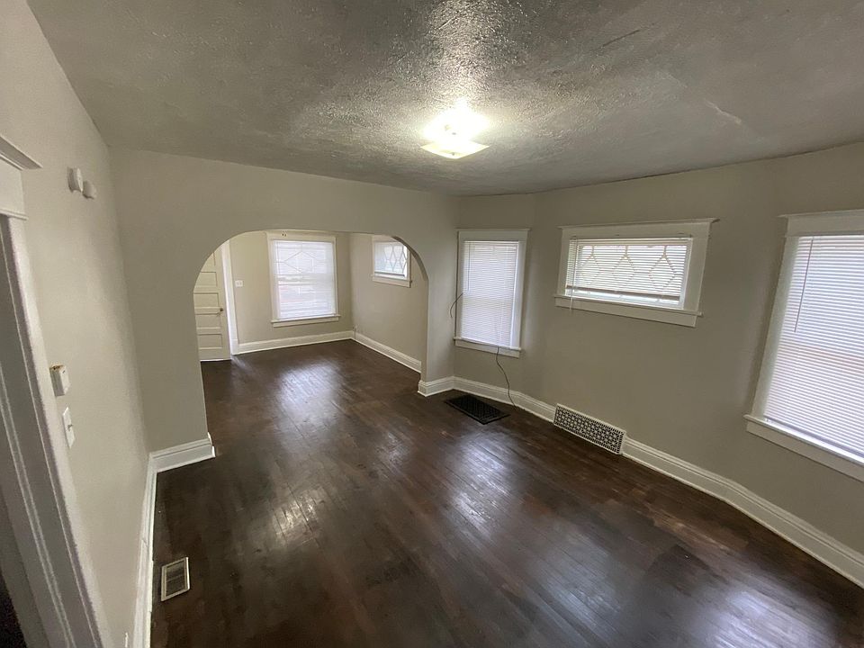 Large dining room with hardwood floors is open to the living room.