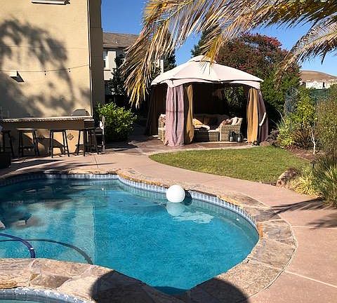 Outdoor bar and pergola alongside pool