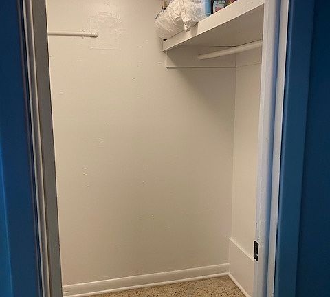 Large walk in closet with 4 drawer dresser.