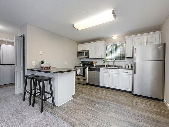 Spacious kitchens featuring wood-style flooring, granite-style countertops, and stainless steel appliances.